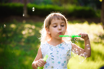 Girl with bubbles at a sunny summer evening