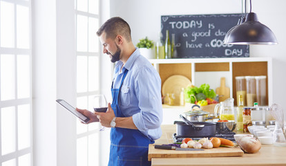 cook with a tablet in hand and studying the recipe