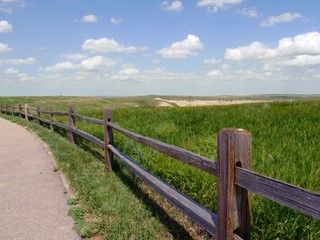Fototapeta na wymiar Wooden fence running along the paved road at Badlands National Park in South Dakota.