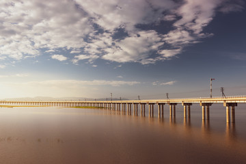 Obraz premium Landscape View of Train crossing Pasak Chonlasit Dam. Reservoir for agriculture at Lopburi,Thailand