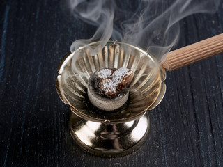 Burning incense in a simple Romanian orthodox censer or incense burner