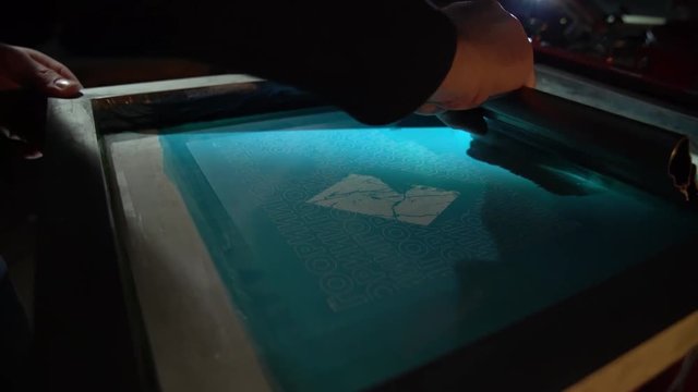 The process of silk screen printing on carousel in dark room. Slow motion close up.  Shooted with 120 fps and rendered to 60 fps with 50% speed