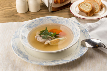 Dietary soup with chicken and egg on wooden table