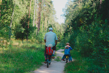 Fototapeta premium active senior with grandkids riding bikes in nature