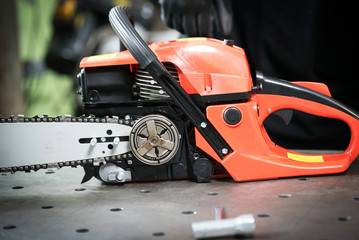 Naklejka premium Work in the workshop, changing the chain in the chainsaw