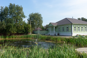 Fototapeta na wymiar green house by the pond with a fountain