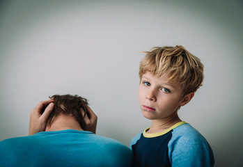 sad child with stressed father, family problems