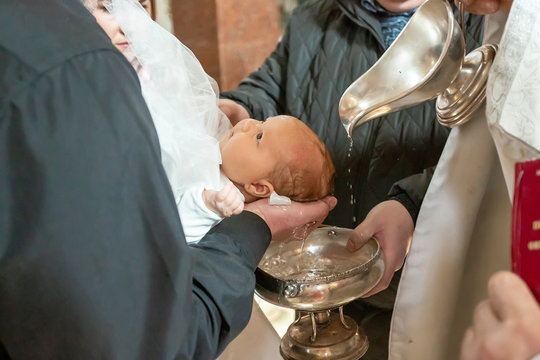 Baptism Ceremony In Church. Pour Holy Water On The Head On A White Blankets, Baptism Christening The Baby At The Orthodox Church