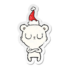 peaceful distressed sticker cartoon of a polar bear wearing santa hat