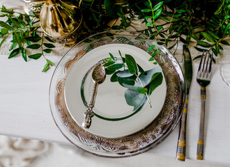 Festive table with greenery and cutlery.