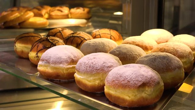 Closeup on Berliner doughnuts on display on a glass shelf in a bakery