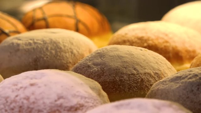Closeup on Berliner doughnuts on display on a glass shelf in a bakery