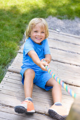 Happy  little boy climbing on outdoor playground