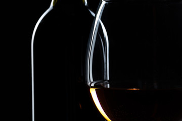 wine bottle and wine glass in a black background