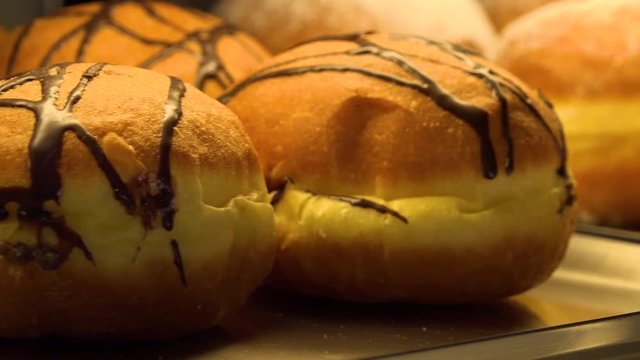 Closeup on chocolate Berliner doughnuts on display on a counter in a bakery