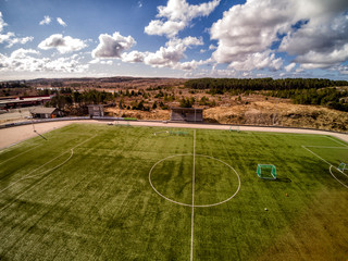 Aerial view of green artificial grass on the field. Shot from the drone.