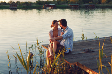 Young loving couple enjoys by the river during the sunset