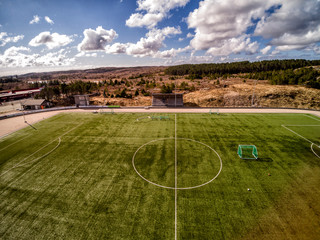 Aerial view of green artificial grass on the field. Shot from the drone.