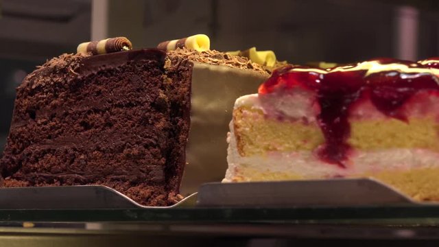 Closeup on various slices of cakes on display in a store