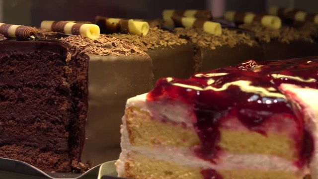 Closeup on various slices of cakes on display in a store