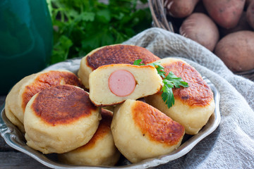 Sausage in potato dough on a metal dish, selective focus