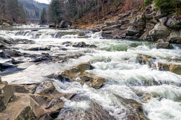 Natural waterfall and stream in the Carpathian mountains in winter time. Landscape with cascade,...