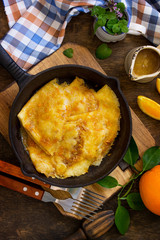 Homemade French pancakes - Crepe Suzette with orange syrup for a delicious breakfast. Top view flat lay background.