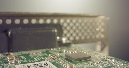 Extreme macro dolly shot of a PCB computer board with capacitors and transistors