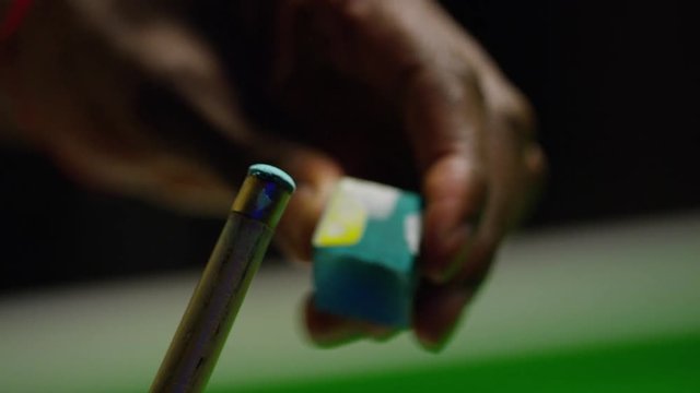 Close up shot of snooker cue having chalk put on the end, in slow motion