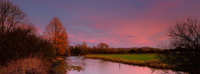 The River Meon at sunset with Old Winchester Hill, Exton, Hampshire, UK