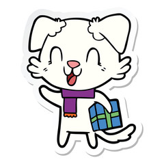 sticker of a laughing cartoon dog with christmas present