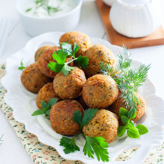 Chickpea falafel with fresh herbs on a white plate, square