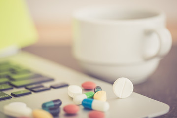 PILLS MEDICINE ON LAPTOP HEALTH CONCEPT