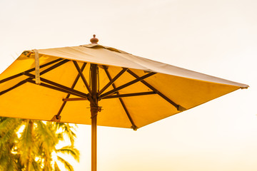 Umbrella and chair on the beautiful beach and sea at sunrise time for travel and vacation
