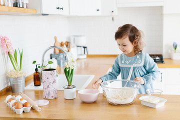 Obraz na płótnie Canvas Little girl preparing easter cookies at the kitchen.