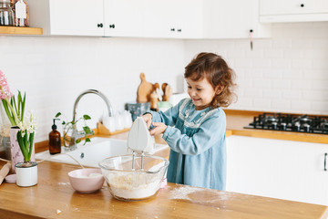 Obraz na płótnie Canvas Little girl preparing easter cookies at the kitchen.