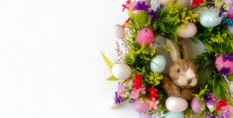 easter wreath with colorful eggs and flowers and a rabbit in the center