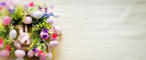easter wreath with colorful eggs and flowers and a rabbit in the center