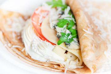 Thin delicious pancake with four types of cheese on white