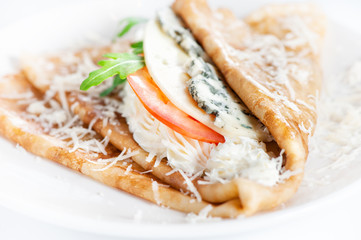 Thin delicious pancake with four types of cheese on white