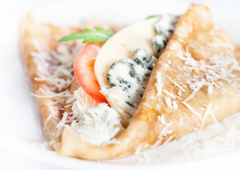 Thin delicious pancake with four types of cheese on white