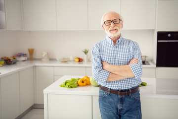Close up portrait grey haired he his him grandpa arms crossed leaning cooking table sincerely...