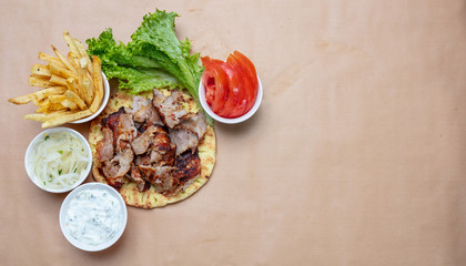Shawarma, gyros on pita bread, vegetables and tzatziki sauce, top view. Traditional turkish, greek meat food.