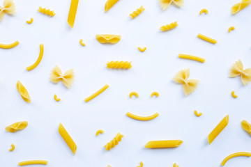 Different types of dry pasta on white.