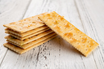 crispy crackers stacked up on white wood background