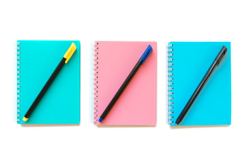 Green pink and blue note books with pens