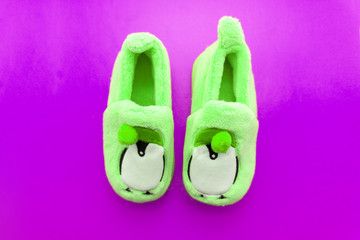 Pair of green textile slippers isolated over white .