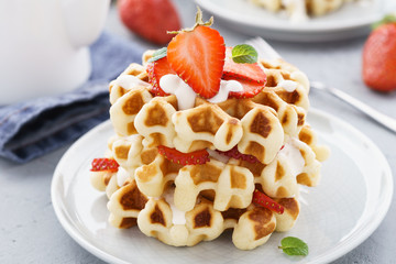 Homemade waffles with strawberries, cream and mint.