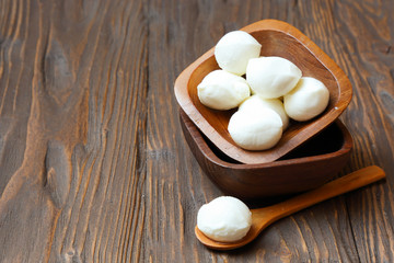 Mozzarella cheese in a wooden bowl on the  table