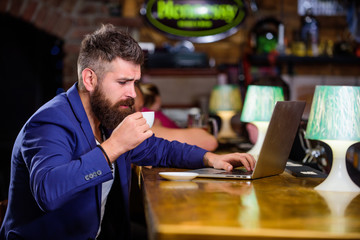 Man bearded businessman sit pub with laptop and cup of coffee. Freelance benefit. Manager work online while enjoy coffee. Online job. Hipster freelancer work online blog notebook. Surfing internet